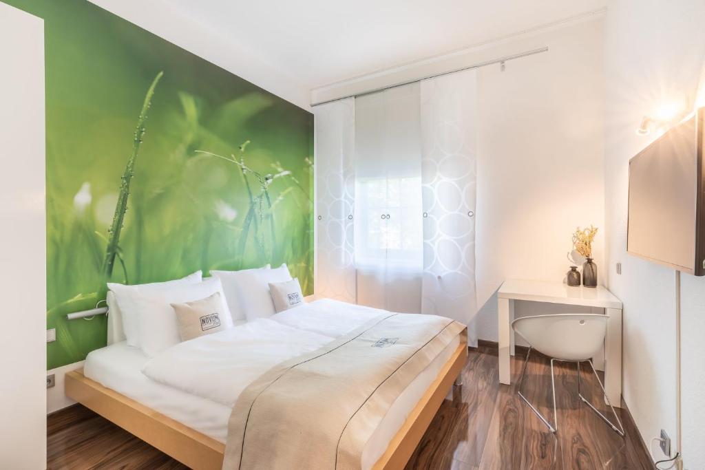 门兴格拉德巴赫Novum Hotel Freiraum的一间卧室设有一张床和绿色的墙壁