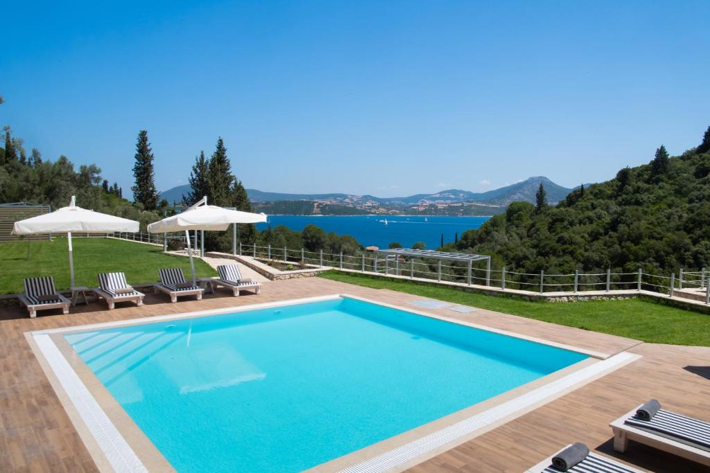 利吉亚Aspasia's mansion的一个带椅子的游泳池,享有水景