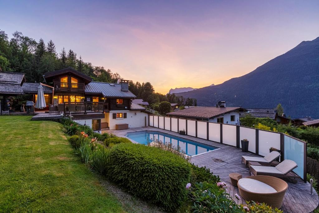 里雾诗Chalet Galadhrim Chamonix Mont Blanc Valley的一座带游泳池和山脉的房子