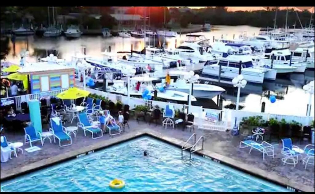 萨拉索塔Remodeled, Huge Pool, Tiki Bar & Grill, Quiet Room的码头上带桌椅和船只的游泳池
