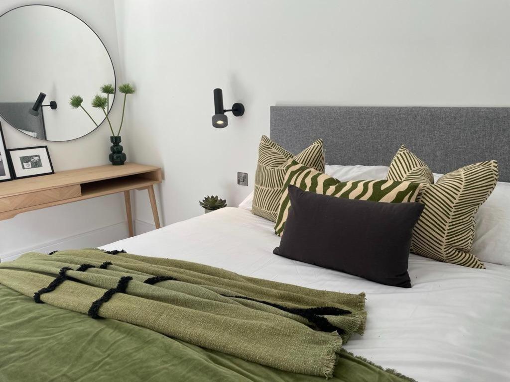 伦敦Brand new 3-bedroom home in London的一间卧室配有带枕头和镜子的床