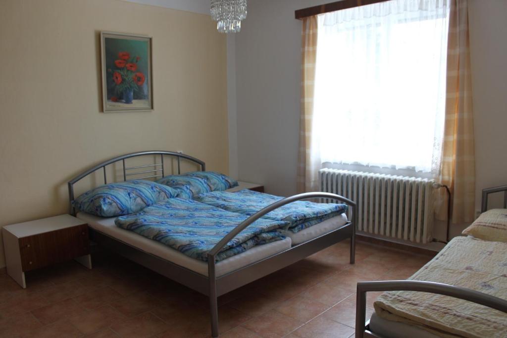 比托福Domek u lesa的一间卧室配有一张带蓝色床单的床和一扇窗户。