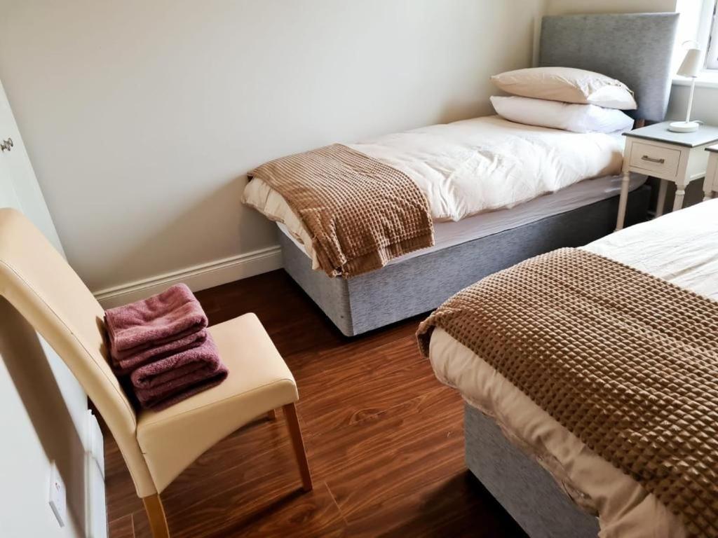 卡拉罗Carraroe Apartment 2的一间小卧室,配有两张床和椅子
