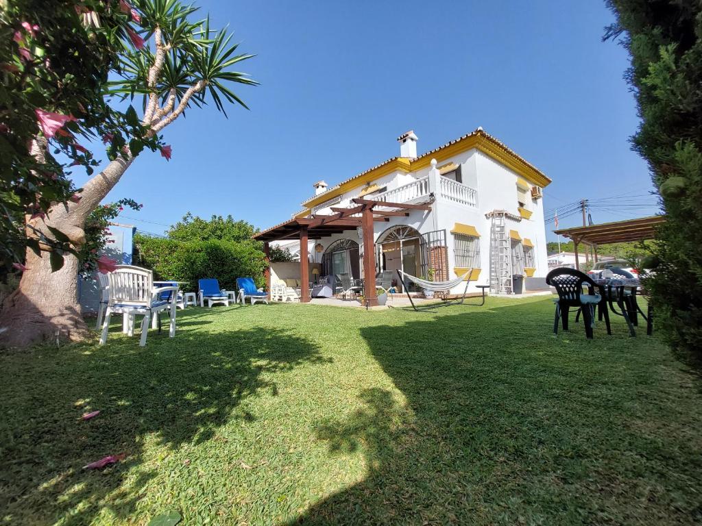 卡拉德米哈斯Beach and Golf House La Cala de Mijas的房屋设有1个带椅子和秋千的院子