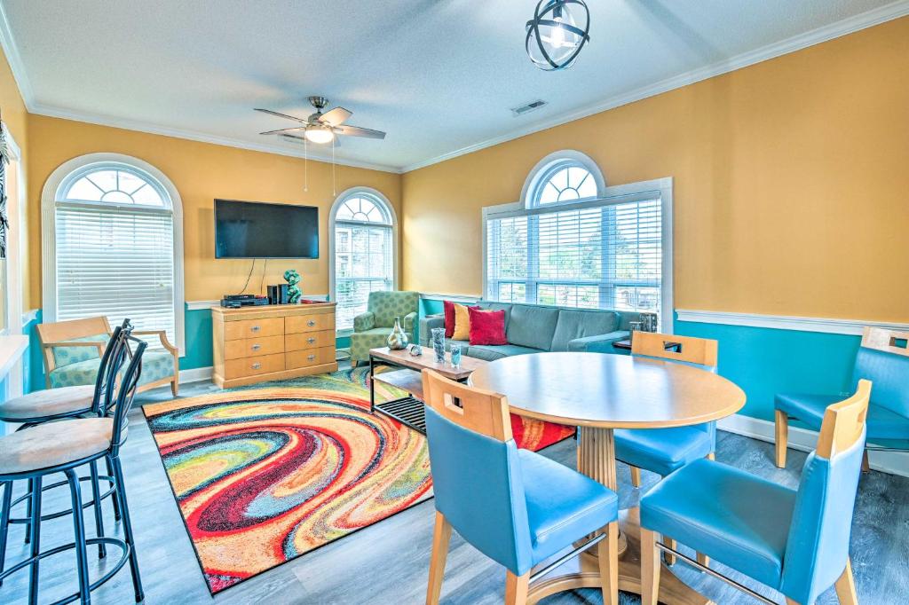 默特尔比奇Colorful Myrtle Beach Golf Club Condo with Pool的客厅配有桌椅和沙发