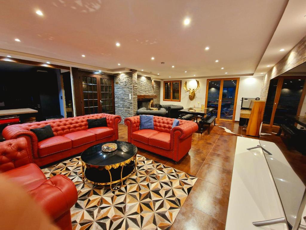 梅塔比耶Place Royale pour 10 à 12 personnes à 30 mèt des pistes de Ski et Vtt的客厅配有红色的沙发和桌子