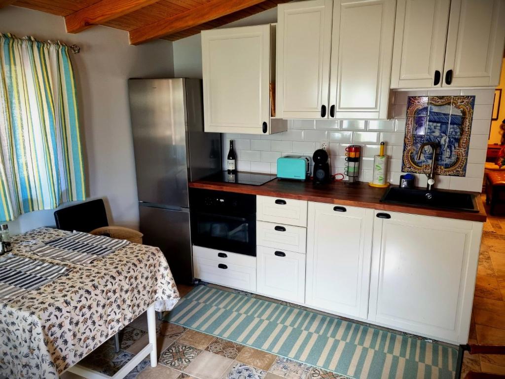SerpinsQuinta do Cabril的一间厨房,配有白色的橱柜和一张位于客房内的床