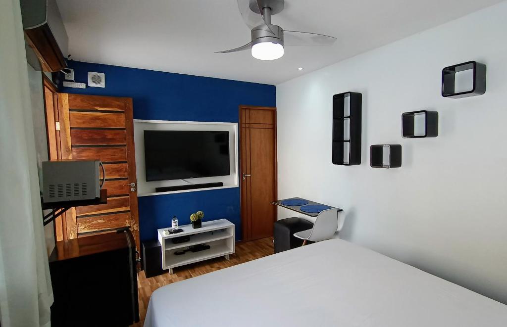 圣路易斯Edícula Próxima a Praias!的卧室配有白色的床和电视