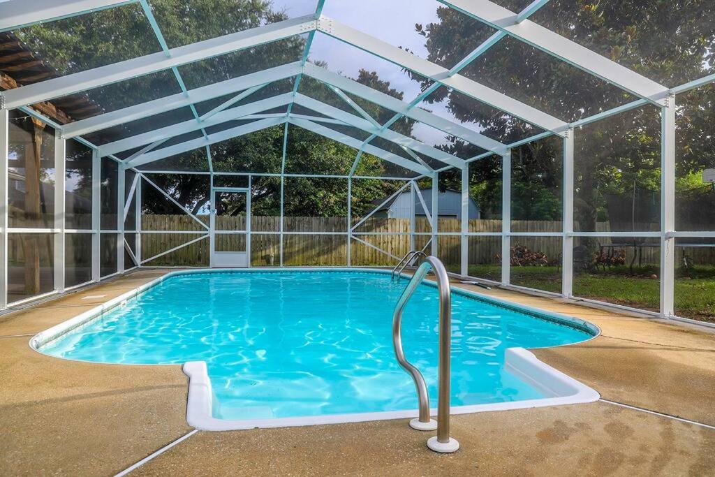 纳瓦拉Pool House, Short Drive to Beach, Grill, Smart TV的游泳池上方有一个透明的塑料屋顶