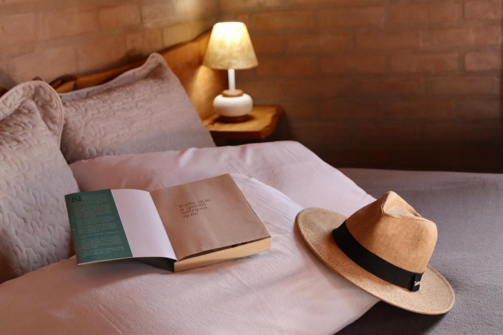 圣安东尼奥-杜皮尼亚尔Refúgio Horse的床上一顶帽子和书