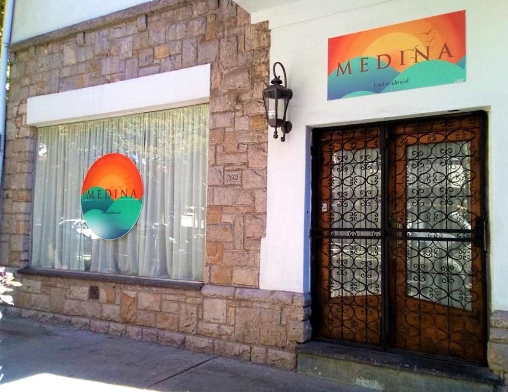 马德普拉塔Hotel Medina B&B的建筑上有一个窗口,上面有标志