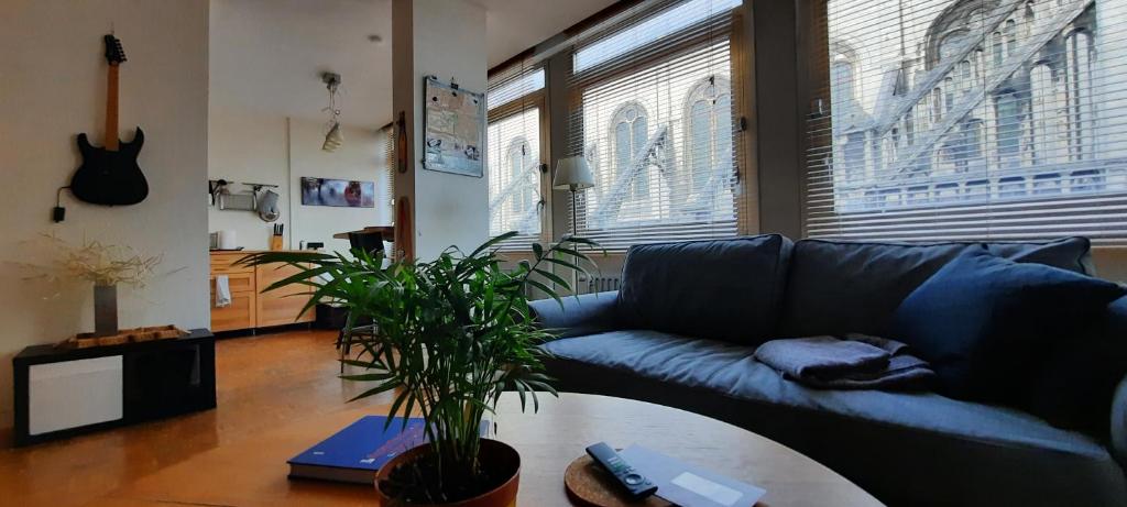布鲁塞尔St Catherine - Sweet home - Bxl - Studio Apartment with city view的客厅配有蓝色的沙发和桌子
