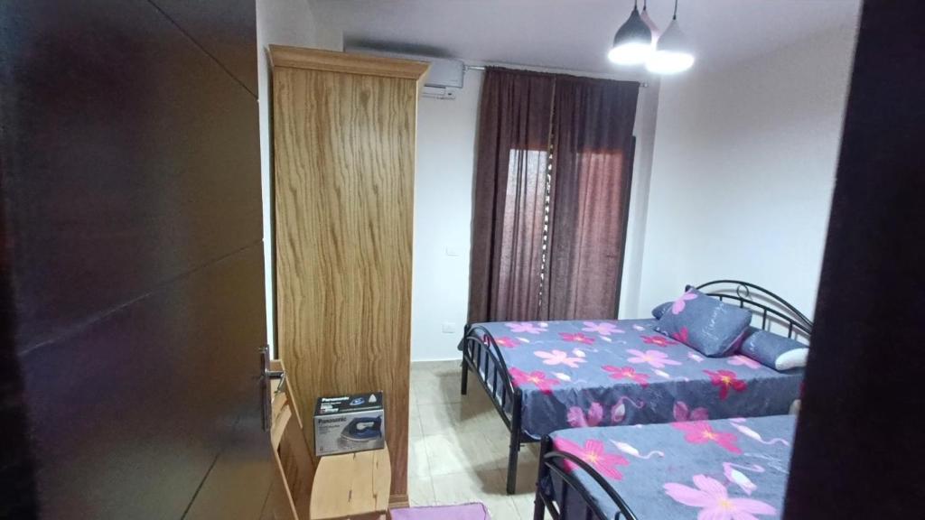 Al Ḩammāmصيف في جراند هيلز الساحل الشمالي的一间设有两张床的房间和一扇通往卧室的门