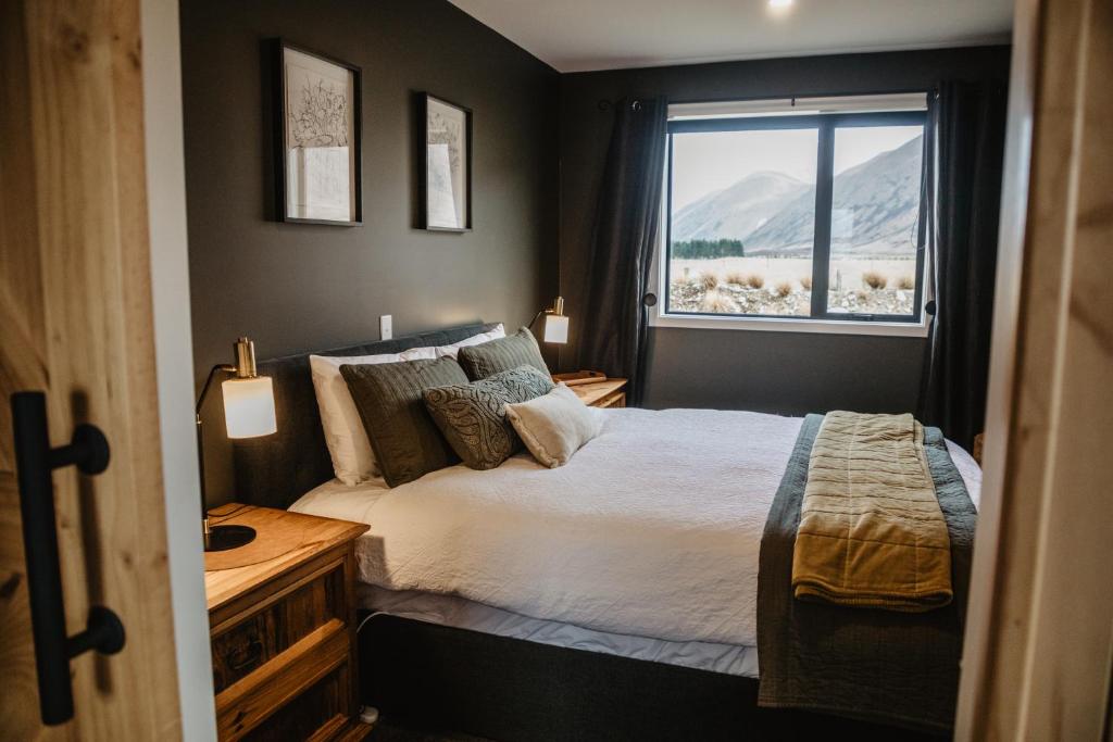 特威泽尔Peak View Cabin - Ben Ohau - Stylish Seclusion的一间卧室设有一张床和一个窗口