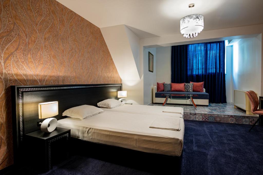 旧扎戈拉优雅酒店的一间卧室配有一张大床和一张沙发