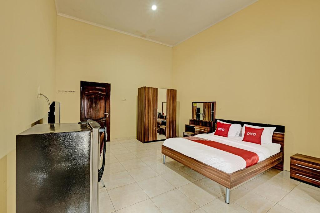 SeturanOYO 91522 Candi Gebang Guesthouse的一间卧室配有红色枕头的床