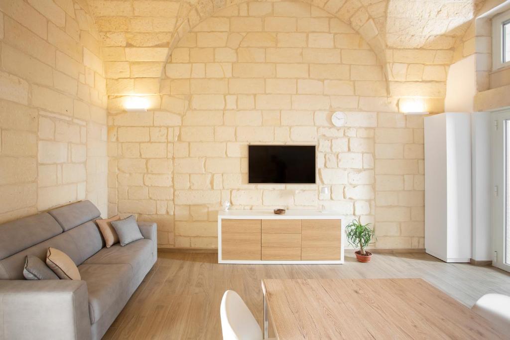 莱切DonCarlo Suite Relais - Free Parking-parcheggio gratuito的客厅配有沙发和墙上的电视