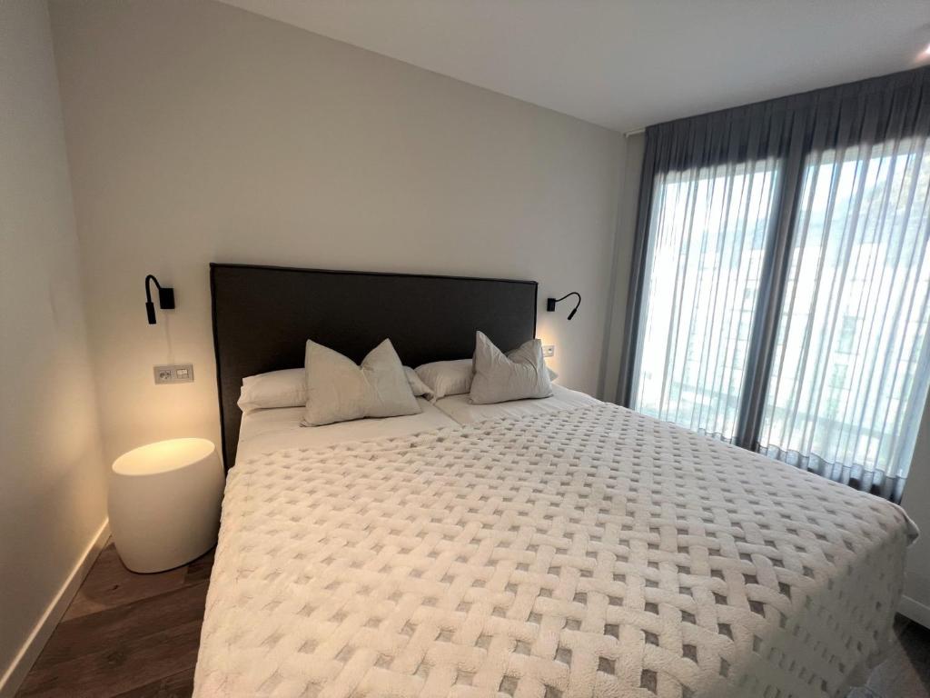 安道尔城Apartaments Turístics Conseller的一间卧室设有一张大床和大窗户