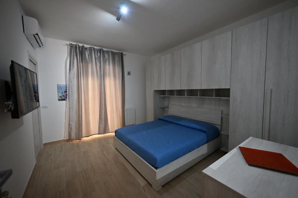 卡利亚里eliterooms的一间卧室设有蓝色的床和窗户。