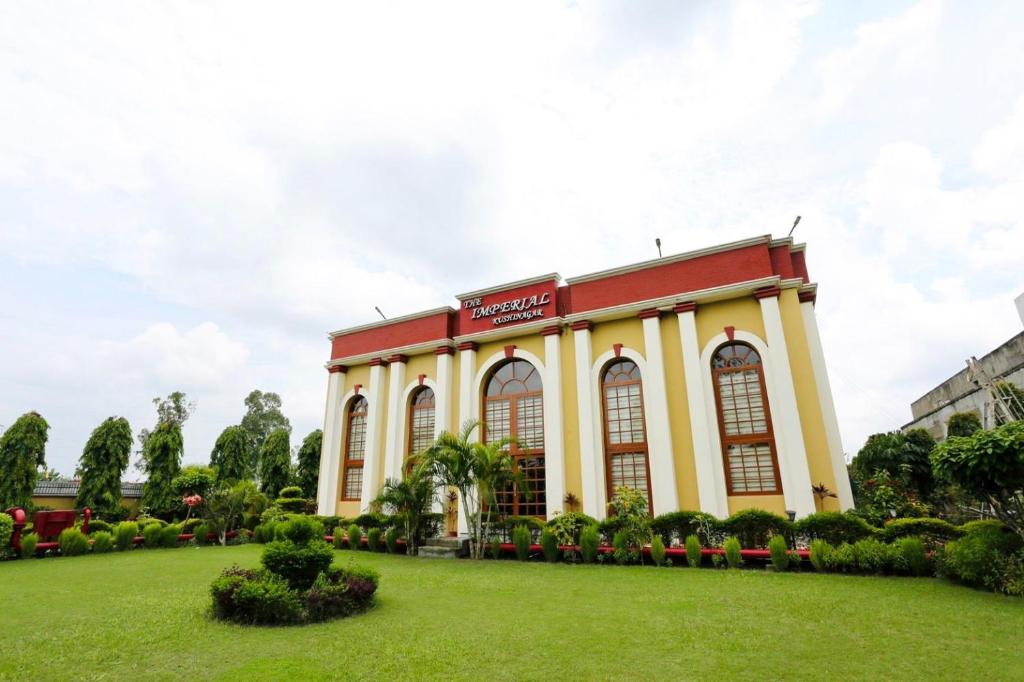 Kushinagar拘尸那迦帝国酒店的前面有草坪的建筑