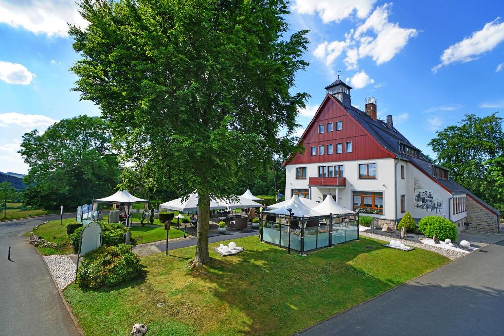 艾本施托克武德恩德餐厅酒店的前面有一棵树的白色大建筑