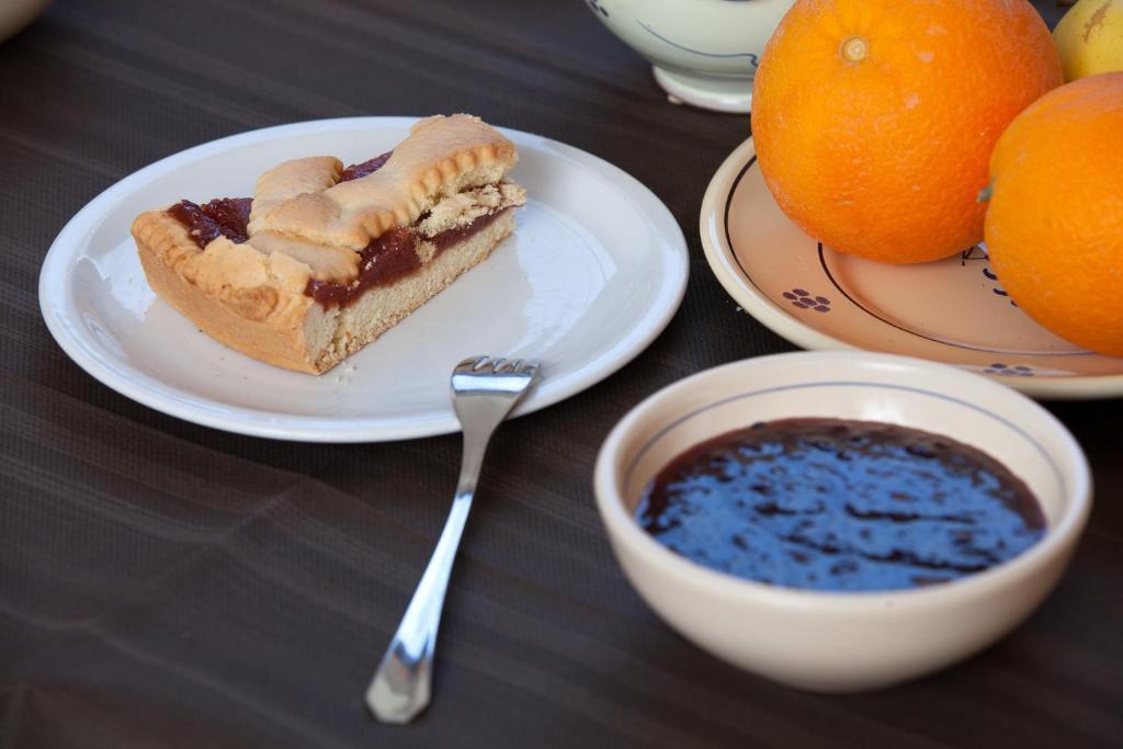 阿尔贝罗贝洛多纳泰罗酒店的盘子上的一块蛋糕,放在一碗水果旁边