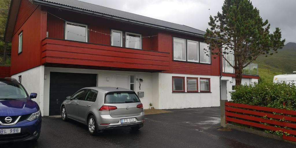 SelatraðLovely 1 BR condo with free parking on premises的停在红白色建筑前面的汽车