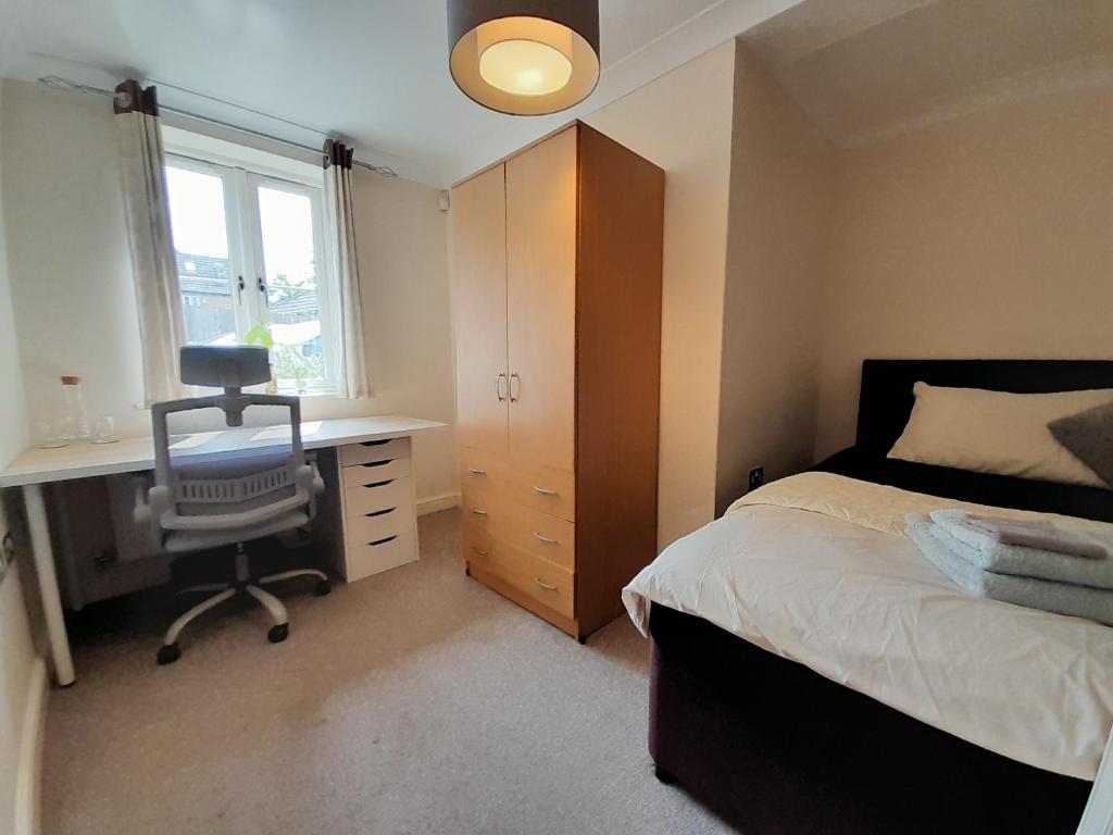 牛津Private rooms in a shared house in Oxford - Host lives in the property的一间卧室配有一张床、一张桌子和一把椅子