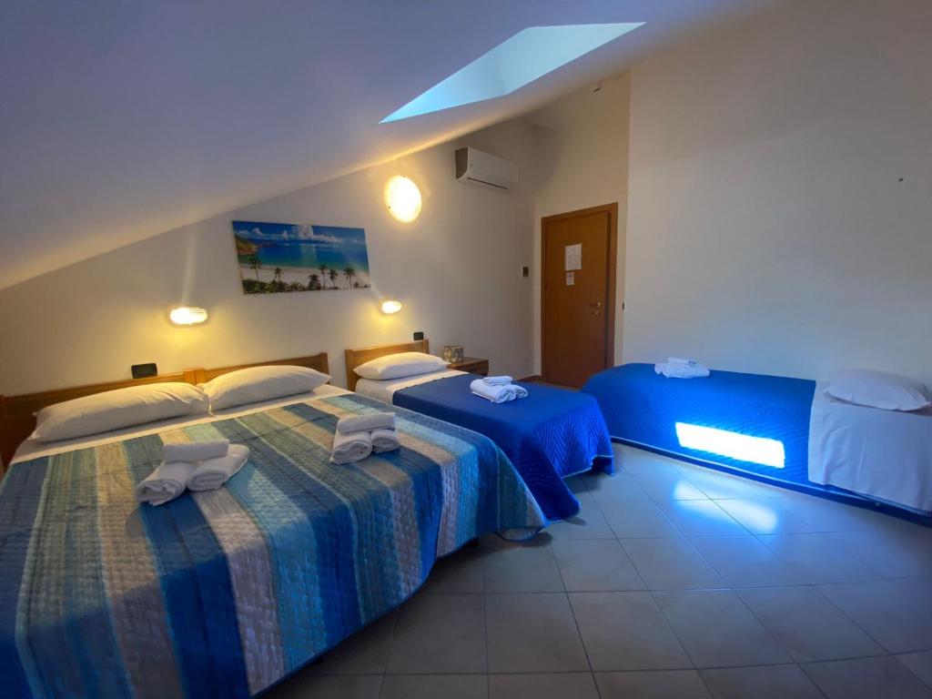 里米尼Hotel Dream的酒店客房设有两张床和窗户。