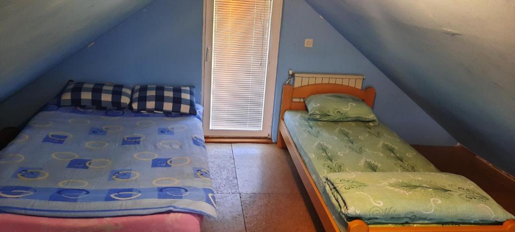 新瓦罗什Vila Vasojević的一间卧室设有两张床和窗户。