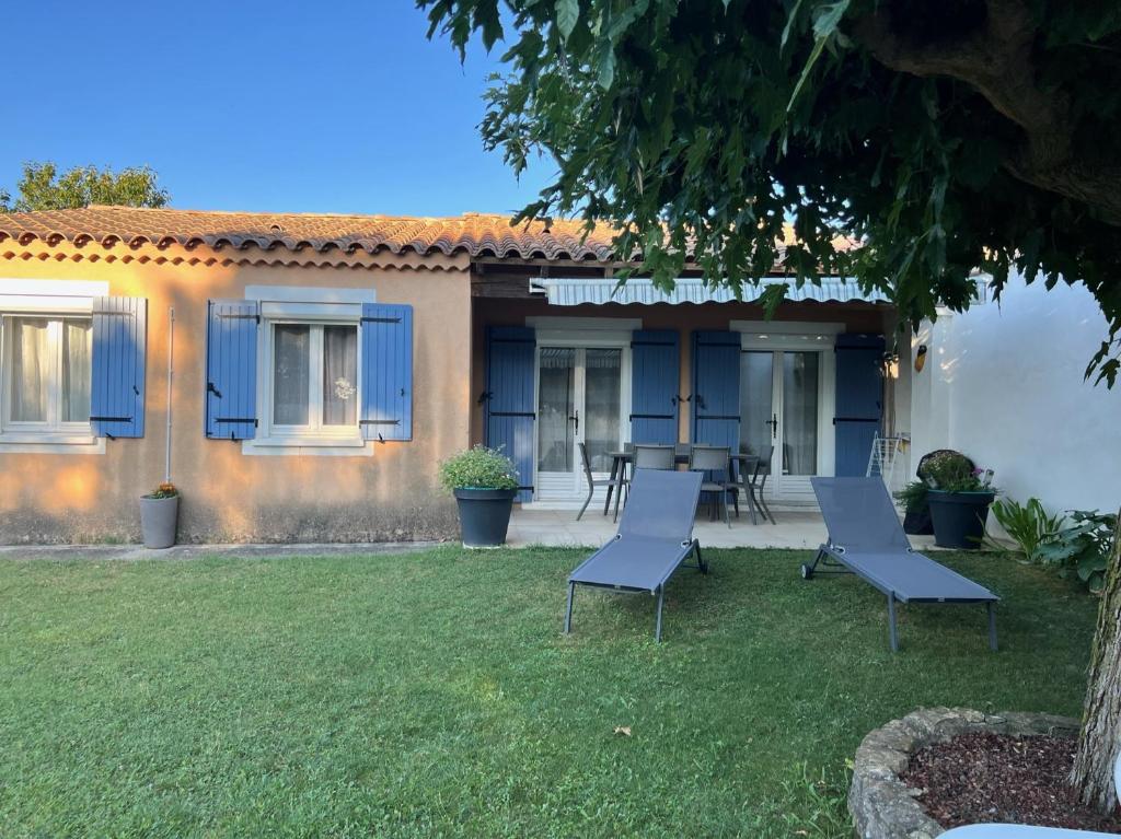 艾居厄河畔卡马勒La Villa de l'Aygues的院子里有蓝色门和椅子的房子