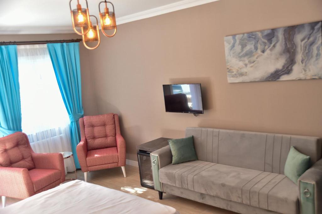 王子岛群Noya Köşk Otel的客厅配有沙发、两把椅子和电视