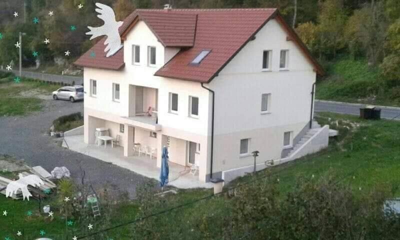 波斯托伊纳Sobe pri Roži的一座大型白色房屋,设有红色屋顶