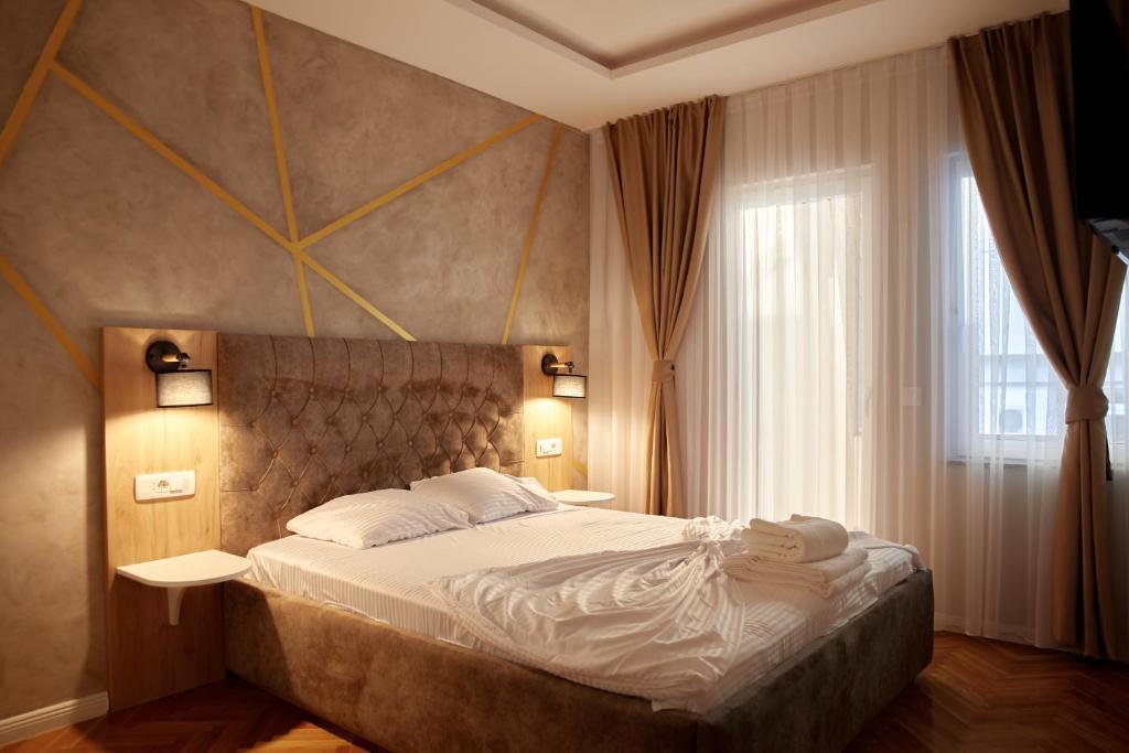 普里什蒂纳Amico Hotel的一间卧室设有一张大床和一个窗户。