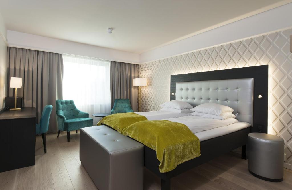 桑维卡松恩会议酒店的一间卧室配有一张带绿毯的大床