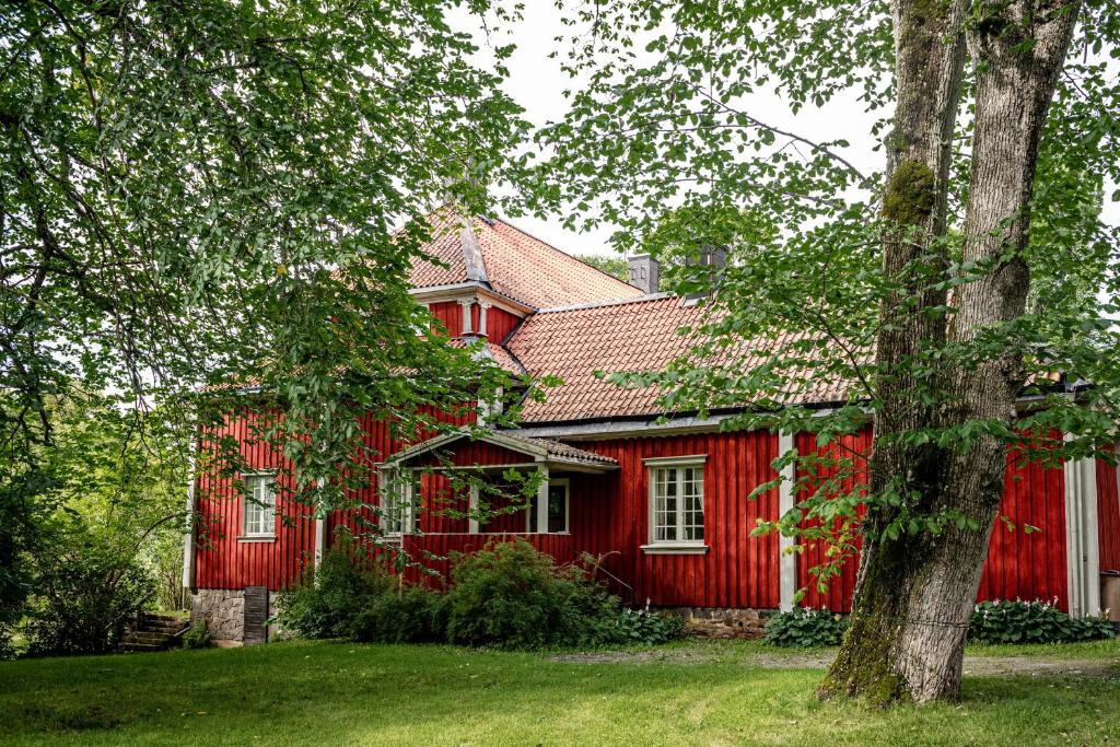 BorgvikBorgviks herrgårdsflygel的前面有一棵树的红色房子