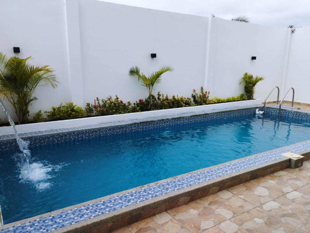 曼塔Hostal Las Orquideas的大楼内的一个蓝色海水游泳池
