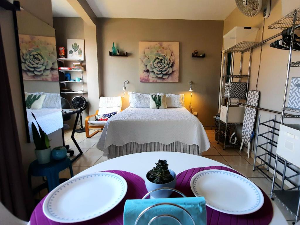 特古西加尔巴Cómodo Apartamento privado的一间设有床和两张桌子及架子的房间