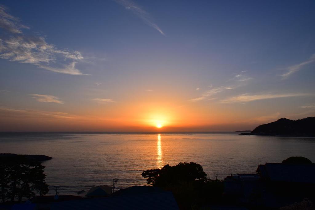 热海热海方丹布鲁酒店的日落在水面上