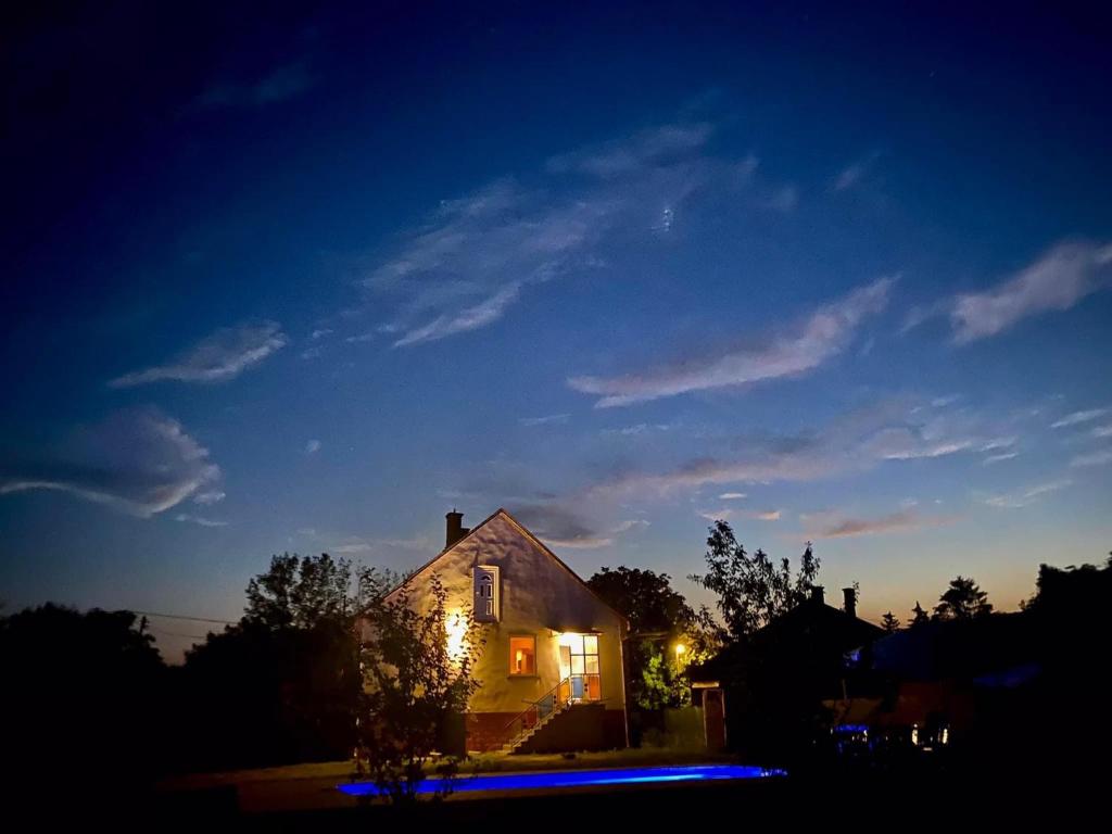 ÁroktőRiver House - Luxury house on the border of the Tisza River的夜晚点亮的房屋,灯火在里面