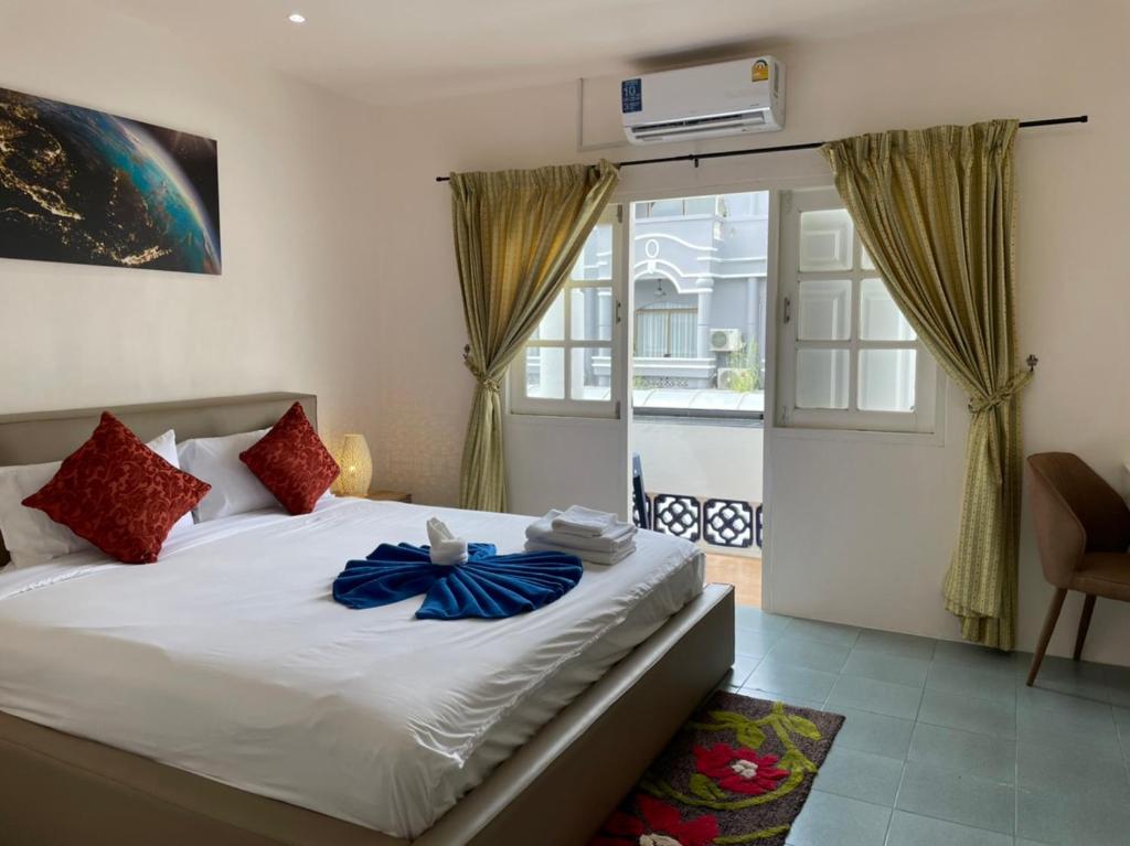 芭东海滩Inn Dulgence的一间卧室设有一张床和一个滑动玻璃门