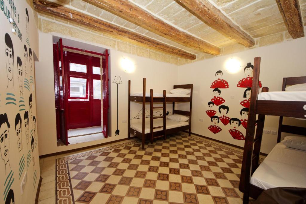 瓦莱塔Vallettastay Dormitory shared hostel的一间设有红色门的房间和一间卧室