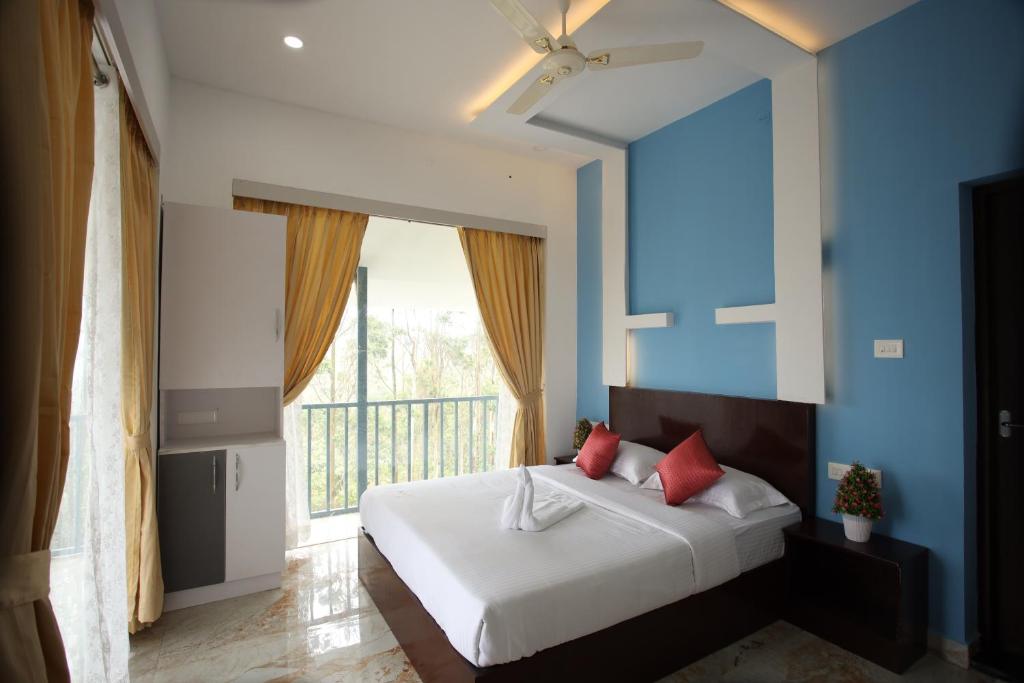 伊都基Paadi Holidays Idukki的一间卧室配有一张蓝色墙壁的床和一扇窗户