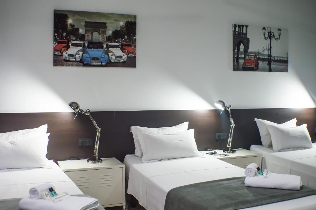 瓦伦西亚Quart Youth Hostel & Apartments的酒店客房设有两张床和两盏灯。