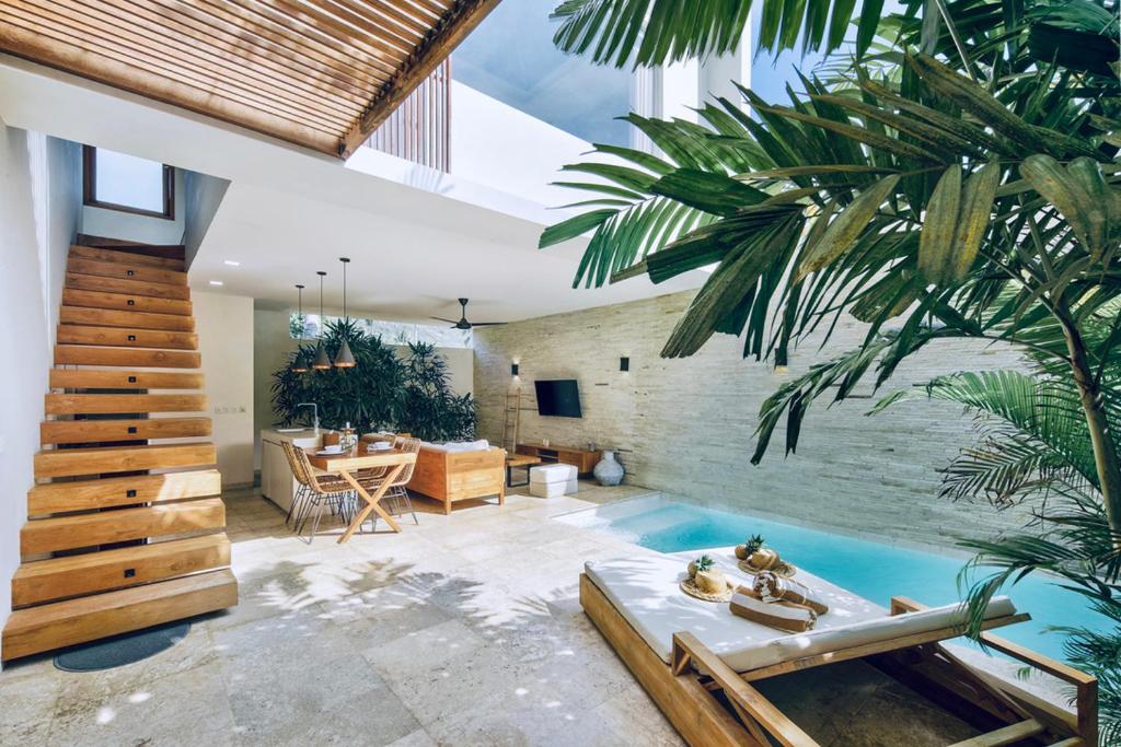 龙目岛库塔Kabila Villas的一个带游泳池和房子的客厅