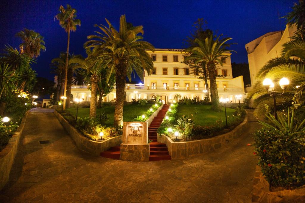丹吉尔法国别墅格兰德酒店的一座棕榈树和灯光的建筑