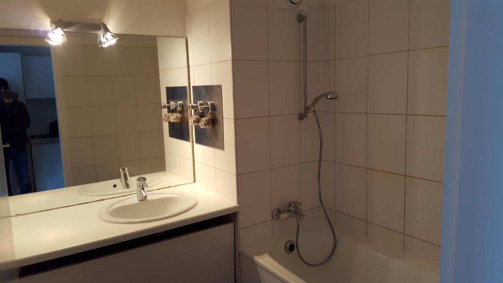 科隆FeWo Hostel的浴室配有盥洗盆和带镜子的淋浴