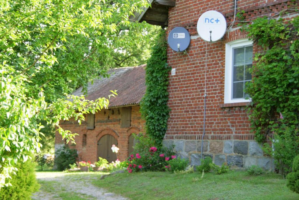 JonkowoAgroturystyka Pod Dębem的砖屋,旁边标有标志