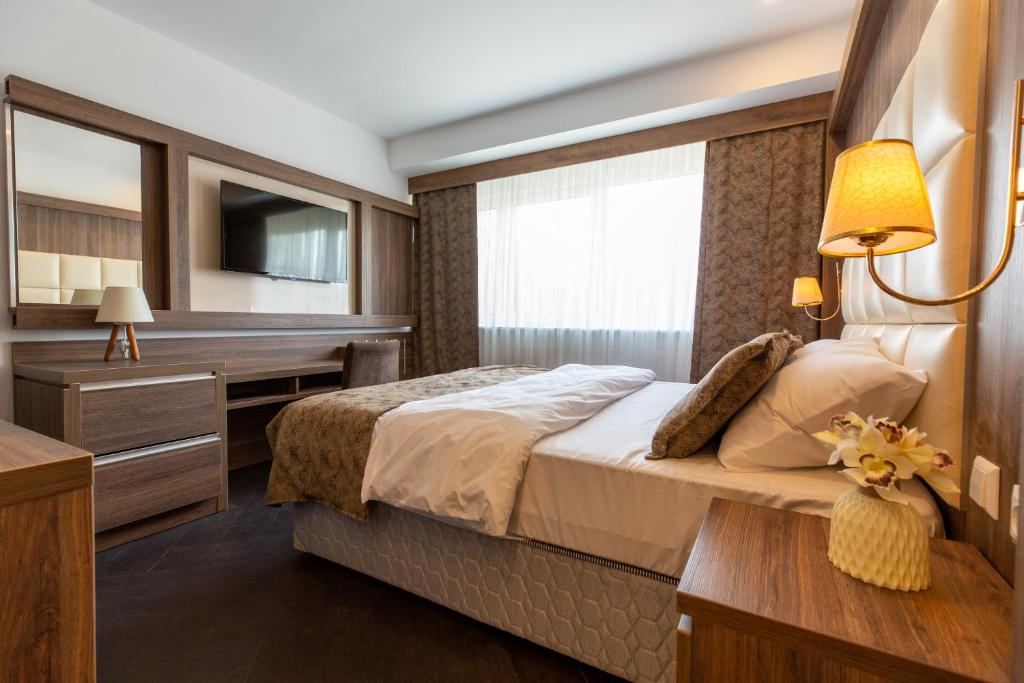 阿尔梅勒Hotel Cataleya的一间卧室配有一张床、一张书桌和一台电视