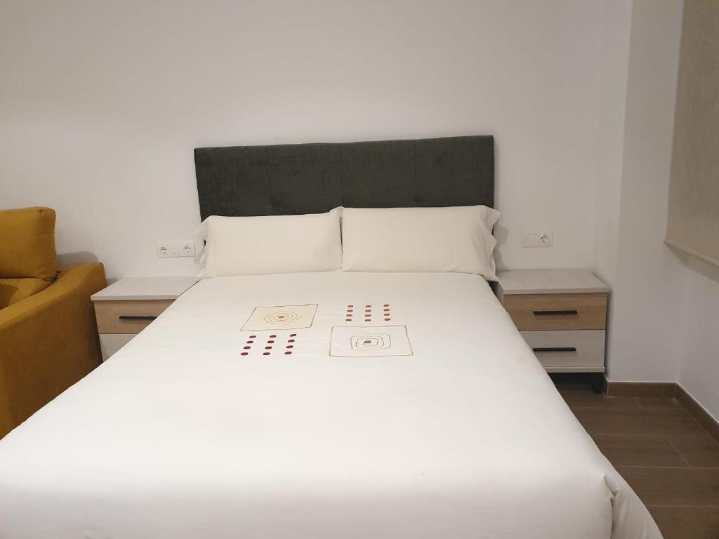 阿达莱斯Apartamento Trinidad Grund的一间卧室配有白色床和2个床头柜